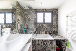 La salle de bains est pourvue d'une baignoire et d'un lavabo. dans l'établissement GuestReady - Charming Stay near Le Marais, à Paris