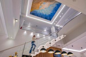 a person walking down a staircase with a painting on the ceiling at Hotel SERHS Rivoli Rambla in Barcelona