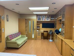 Una habitación de hospital con un sofá y un escritorio. en House 9, en Bangkok