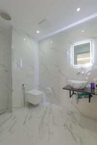 a white bathroom with a sink and a toilet at Vila Sofia in Ksamil