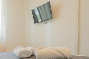 uma cama com toalhas e uma televisão na parede em nuovissimo bilocale a 40 metri dal mare em Alba Adriatica
