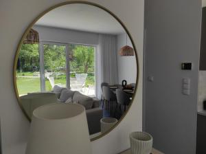 a living room with a couch and a mirror at Źródlana Apartamenty - całoroczne domy na wyłączność in Odargowo