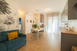 een woonkamer met een blauwe bank en een keuken bij nuovissimo bilocale a 40 metri dal mare in Alba Adriatica