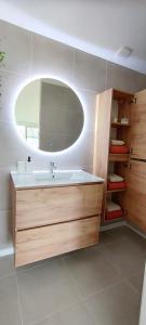 La salle de bains est pourvue d'un lavabo et d'un miroir. dans l'établissement Maison cosy terrasse ensoleillé, à Clermont-Ferrand