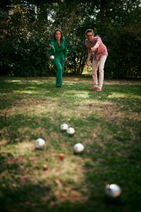 two people standing in a field with balls on the grass at Hotel KÜGLERHOF in Tirolo