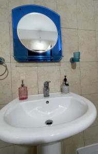 a bathroom sink with a blue mirror above it at Klevi Apartments in Golem