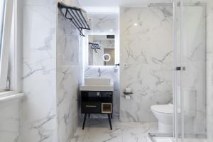 Baño blanco con lavabo y aseo en Lisbon 5 Hotel en Lisboa