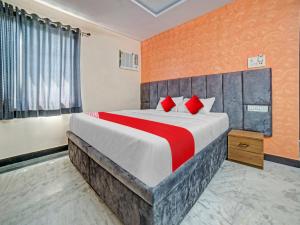 1 dormitorio con 1 cama grande con almohadas rojas en All Seasons Corporate, en Jamshedpur