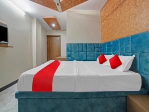 a bedroom with a large bed with red pillows at All Seasons Corporate in Jamshedpur