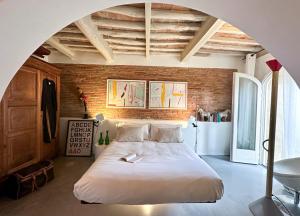 a bedroom with a large bed with a brick wall at Residenza dell'Orto - Residenze Tonnina Group in Guardistallo
