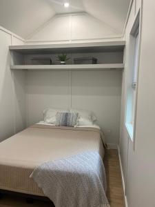 een kleine slaapkamer met een bed in een kamer bij The Overlook Tiny Home in Elizabethtown
