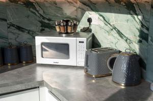 eine Mikrowelle auf einer Küchentheke in der Unterkunft Palm Tree House - Paris in Orpington