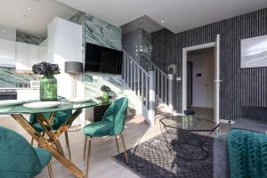 ein Wohnzimmer mit einem Glastisch und grünen Stühlen in der Unterkunft Palm Tree House - Paris in Orpington