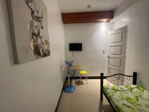 a bedroom with a bed and a table and a chair at Mayon Lodging House in Legazpi