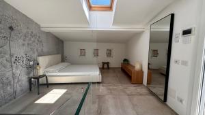a bedroom with a white bed and a mirror at Apartment Città di Mare in Cesenatico