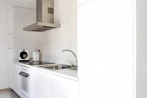 uma cozinha branca com um lavatório e um fogão em 2 bedrooms house with terrace and wifi at Riba de Mouro em Riba de Mouro