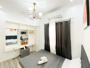 a bedroom with a bed and a desk and a mirror at Ronina's Sipocot Hotel in Sipocot