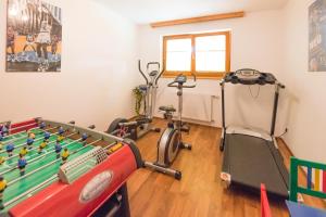 a gym with a ping pong table and exercise equipment at Hotel Pension Appartement Kristall in Tröpolach