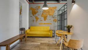 uma sala de estar com um sofá amarelo e uma mesa em Hostellicious em Faro