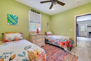 a bedroom with two beds and a dresser and a window at Fire Pit and Beach Access Quiet Northville Retreat in Benson