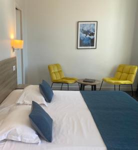 a hotel room with a bed and two chairs at Grand Hôtel De Calvi in Calvi