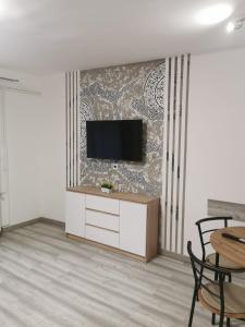 a living room with a television on a wall at Kucko Vendeghaz Guesthouse in Sárospatak