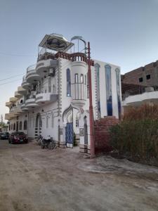 盧克索的住宿－Alaa Aldin Flats，一座白色的建筑,上面设有一个阳台