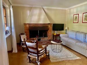 ein Wohnzimmer mit einem Sofa und einem Kamin in der Unterkunft Heerlijke villa met privé zwembad & 5 slaapkamers dicht bij Lucca en Pisa in Monsagrati