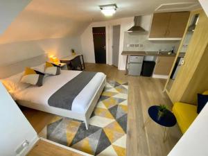 a bedroom with a large bed and a kitchen at Modern 2/3 huge bedrooms Heathrow & Central London in Feltham +10 photos