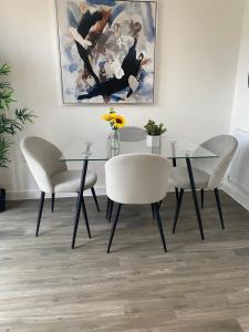 a dining room with a glass table and chairs at Cosy private double room & sofa-bed room in vibrant Hatfield neighbourhood in Hatfield
