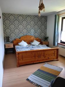 a bedroom with a wooden bed with pillows on it at Smrek Sokolec Agroturystyka in Ludwikowice Kłodzkie