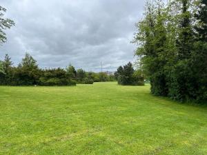 a large field of grass with trees in the distance at Chic & Modern Flat: Perfect for Exploring Kent! in Kent