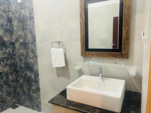 uma casa de banho com um lavatório branco e um espelho. em Lucky Transit Hotel em Katunayaka