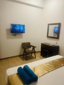 een slaapkamer met een bed, een stoel en een spiegel bij Lucky Transit Hotel in Katunayaka