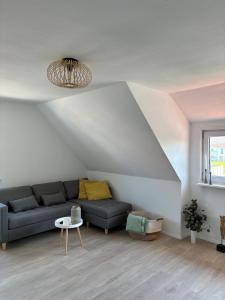 ein Wohnzimmer mit einem Sofa und einem Fenster in der Unterkunft Ferienwohnung Alpenblick in Benningen