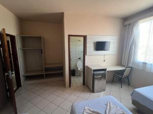 a room with a bathroom with a toilet and a desk at Hotel Central in Porto Velho