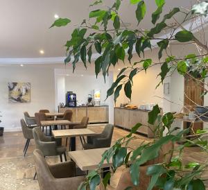 a restaurant with wooden tables and chairs and plants at Grand Hôtel De Calvi in Calvi