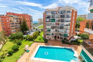 an apartment with a pool in front of a building at Capela de Steram Flats Torremolinos in Torremolinos