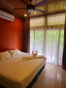 a bedroom with a bed with a heart on it at Caribbean Sea Towers Hotel in Puerto Viejo
