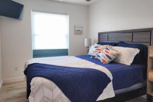 1 dormitorio con cama con sábanas azules y ventana en Lakeshore Villas, en Corpus Christi