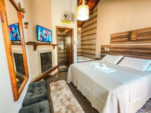 una camera d'albergo con un letto e un bagno di Chalés Galinha Da Roça a Monte Verde