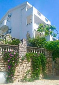 a building with flowers on a stone wall at Apartmani Jovanovic in Petrovac na Moru