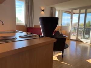 eine Küche mit einer Theke und einem Stuhl in einem Zimmer in der Unterkunft Appartementhotel Röhrenbach in Immenstaad am Bodensee