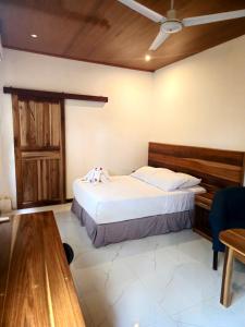 Schlafzimmer mit einem großen Bett mit einem Kopfteil aus Holz in der Unterkunft Caribbean Sea Towers Hotel in Puerto Viejo