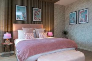 奧平頓的住宿－Palm Tree House - Namaste，一间卧室配有一张大床,配有粉色床单和粉色灯具。