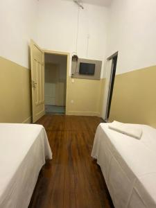 Zimmer mit 2 Betten und einem TV an der Wand in der Unterkunft Hotel Central in Araçatuba
