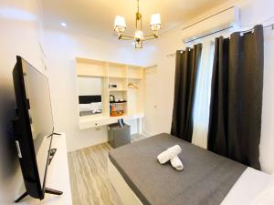 SipocotにあるRonina's Sipocot Hotelのベッド1台とテレビが備わる小さな客室です。