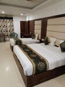 a hotel room with two beds and a desk at Hotel Ambience Dilli 37 At - Near IGI Airport in New Delhi