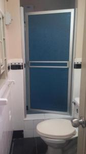 a bathroom with a toilet and a blue door at Sumaq Wasi Barranco II in Lima