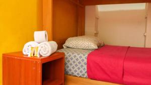 Sumaq Wasi Barranco II في ليما: غرفة نوم مع سرير ومناشف على طاولة
